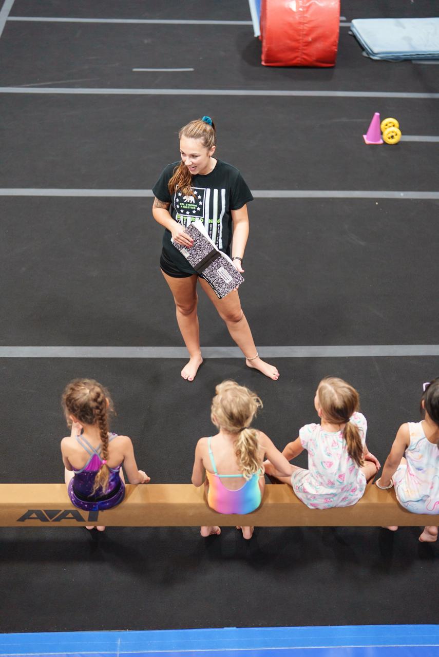 Coach teaching on beam