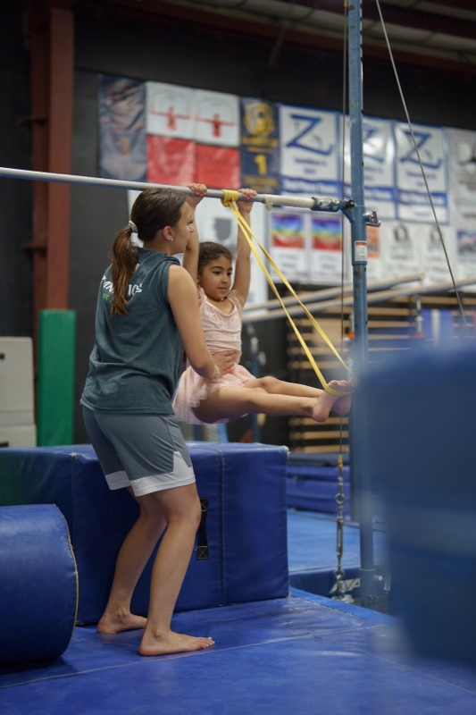 Young children practicing on gymnastics equipment
